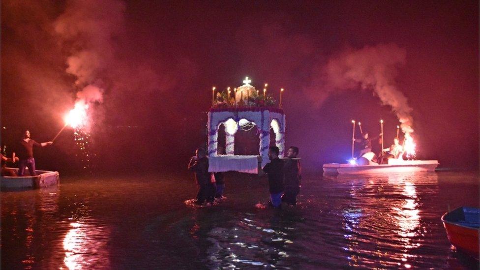 Greek Orthodox Christians carrying the epitaph in water on Good Friday