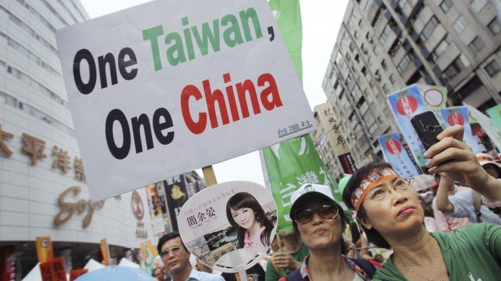 In this June 26, 2010 file photo, anti-China demonstrators hold placards denouncing the Economic Cooperation Framework Agreement (ECFA) planned with China, in Taipei, Taiwan.