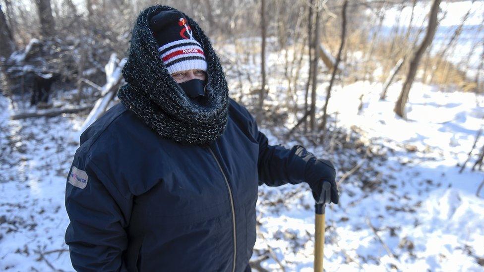 Man in the snow holding a shovel