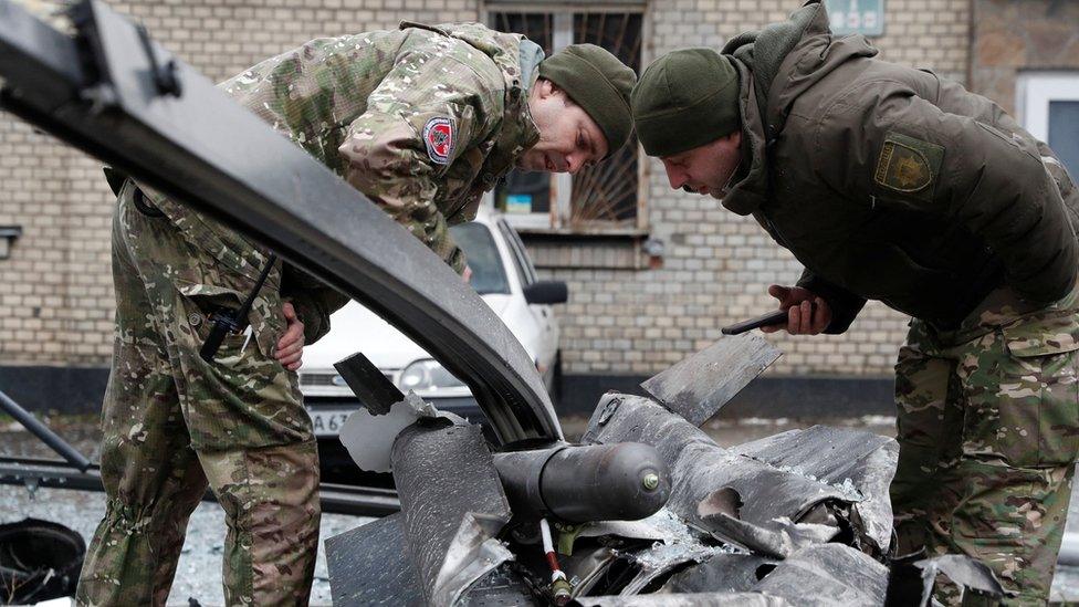 Soldiers examine the remains of a missile near Kyiv