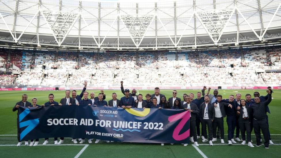 The players pose for a group photo before the Soccer Aid for UNICEF match