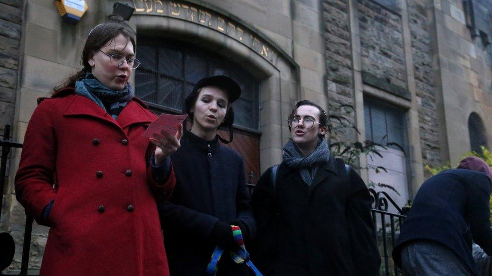 Jewish people singing outside the synagogue in the rain