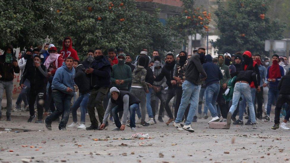 Protesters throw stones during demonstrations against rising prices and tax increases, in Tebourba, Tunisia, January 9, 2018.