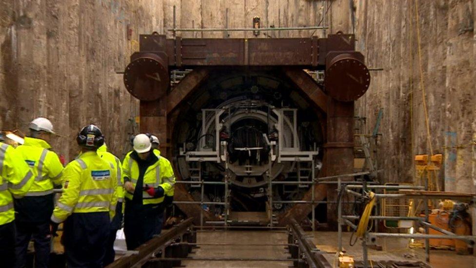 Work men in front of a hole in a huge wall