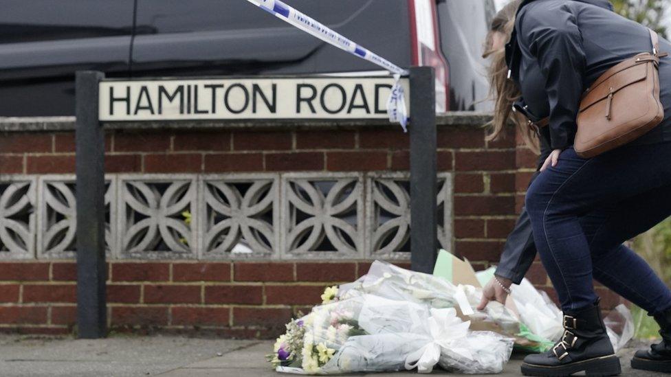 Woman lays flowers on Hamilton Road