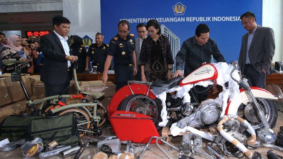 Indonesia's state-owned enterprises minister Erick Thohir (2nd R) and Indonesia's Finance Minister Sri Mulyani (C) check a Harley Davidson motorcycle.