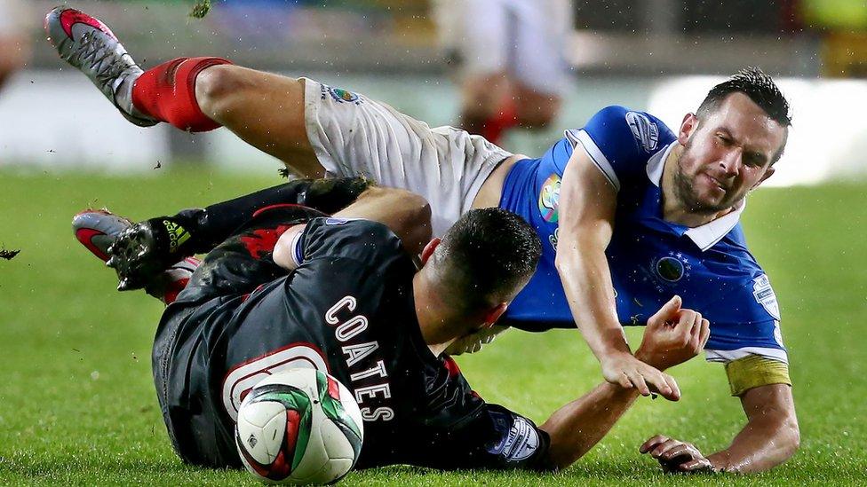 Opposing skippers Colin Coates of Crusaders and Linfield's Andrew Waterworth hit the deck during the Irish Premiership clash at Windsor Park