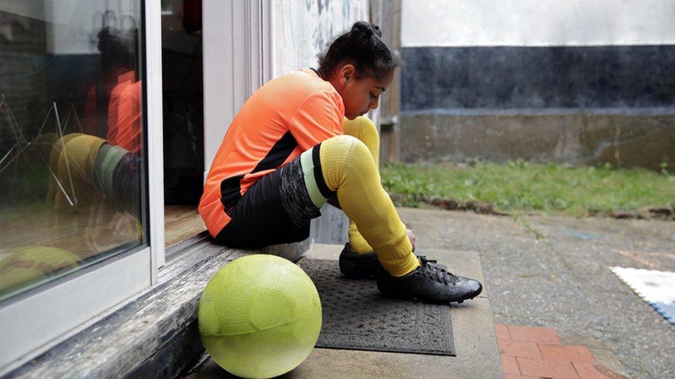 Girl tying up football boots