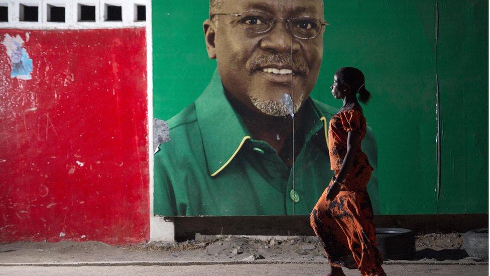 A woman walks past an election billboard of John Magufuli 29 October 2015