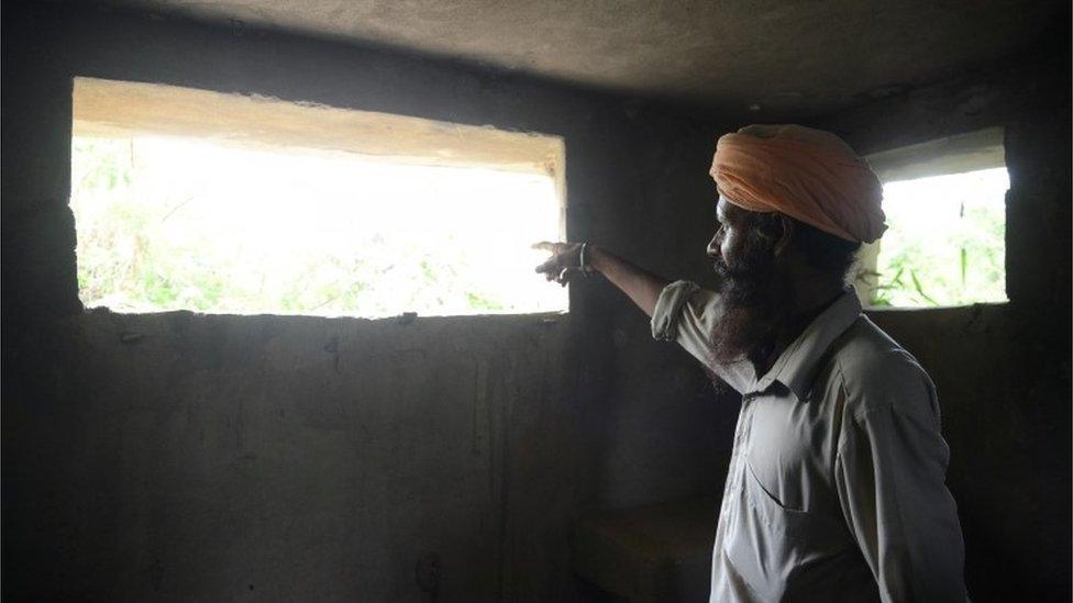 An Indian border area villager looks out of a military bunker at the Indian/Pakistan border village Chak Allah Bakash, about 45km from Amritsar on September 30, 2016,