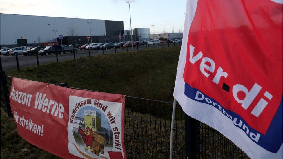 A trade union protest banner reads, "Together we are strong! We are on strike", on a fence of the Amazon logistic centre in Werne, Germany, 29 November 2019