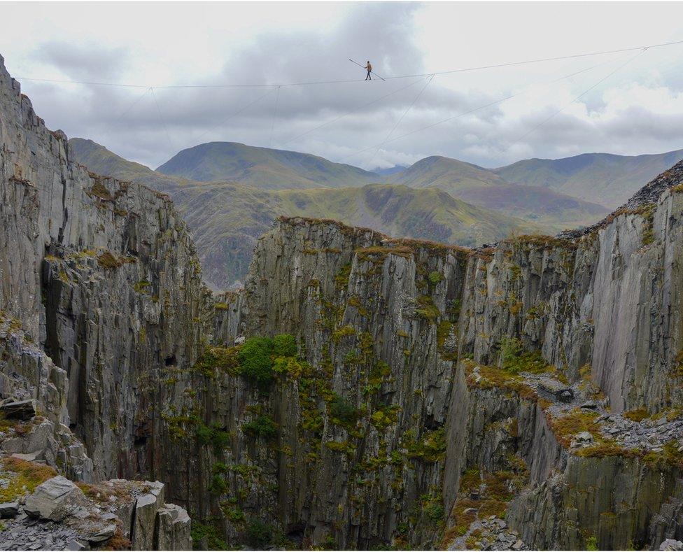 Ellis Grover yn cerdded dros chwarel yn Ninorwig