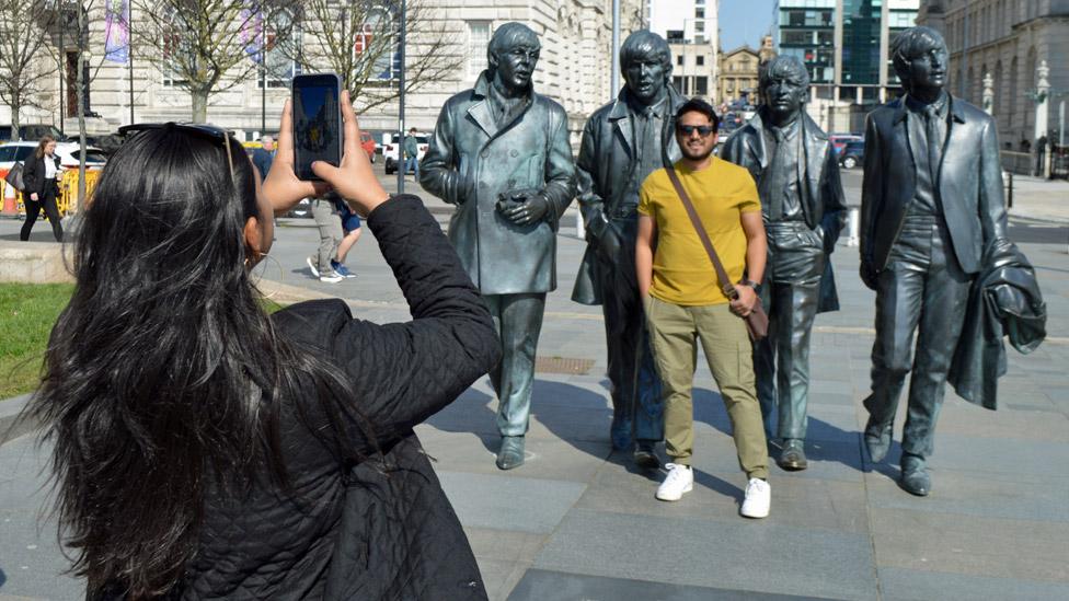 Tourists taking photo at the Beatles statue in Liverpool, 18 April 2023