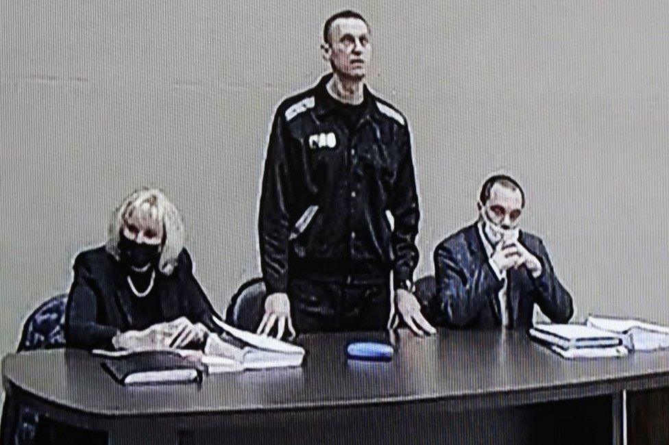 Russian opposition leader and activist Alexei Navalny (C) is seen on a screen during an offsite court session in the penal colony N2 (IK-2) in Pokrov, Vladimir region, Russia, on 15 February 2022