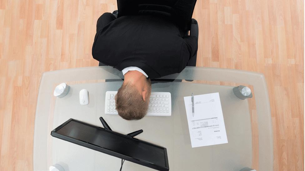 A man sleeping at his desk