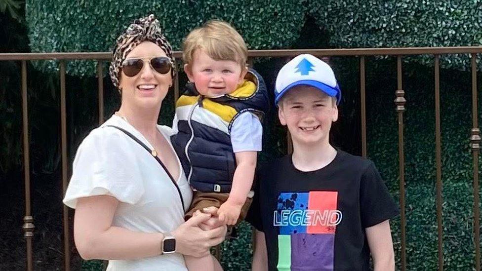 Donna-Marie Cullen pictured wearing a head scarf, smiling with her two children