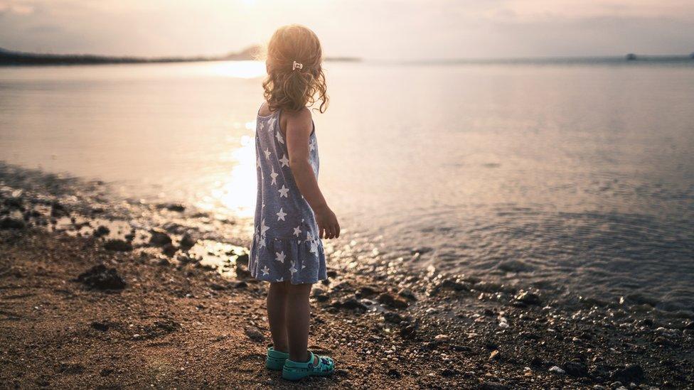 A young girl looking out to sea