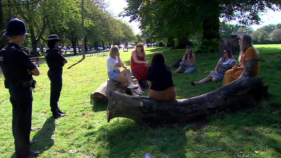 A group of students in a Bristol park with police enforcing coronavirus restrictions