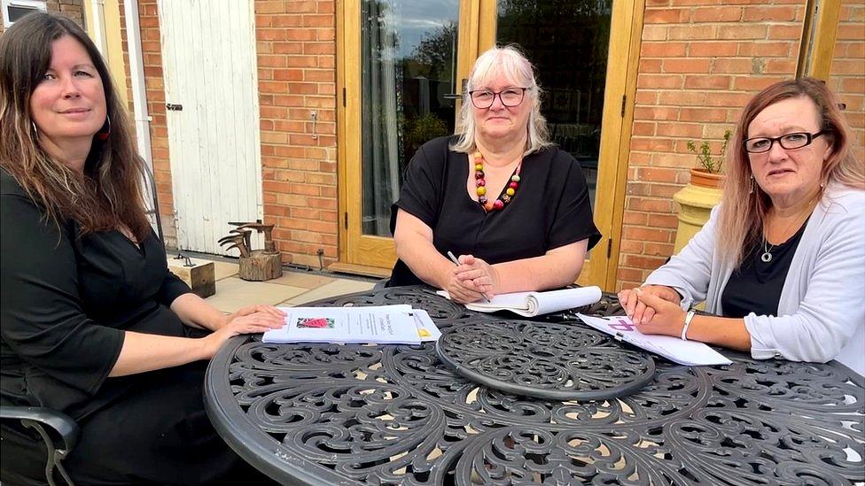 Three women sat around a table