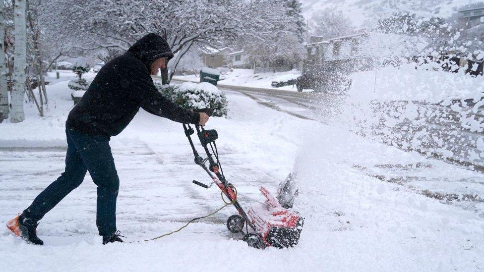 A man clears his driveway of snow