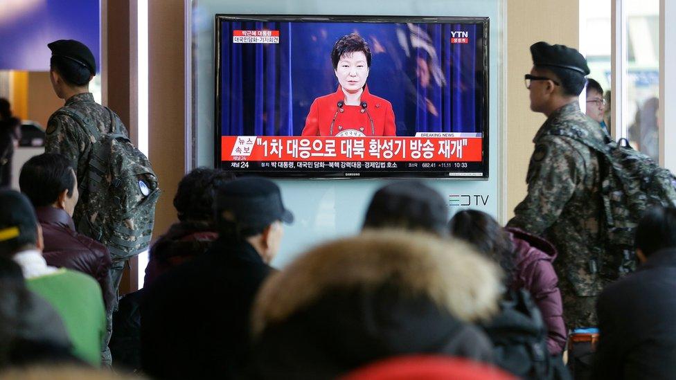 People watch a TV screen showing the live broadcast of South Korean President Park Geun-hye's press conference