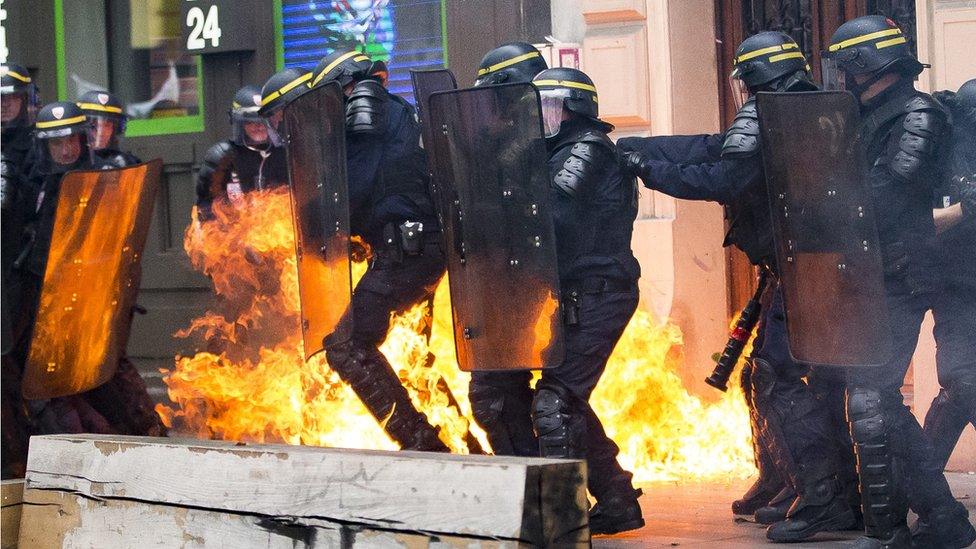 A molotov cocktail explodes next to French riot police