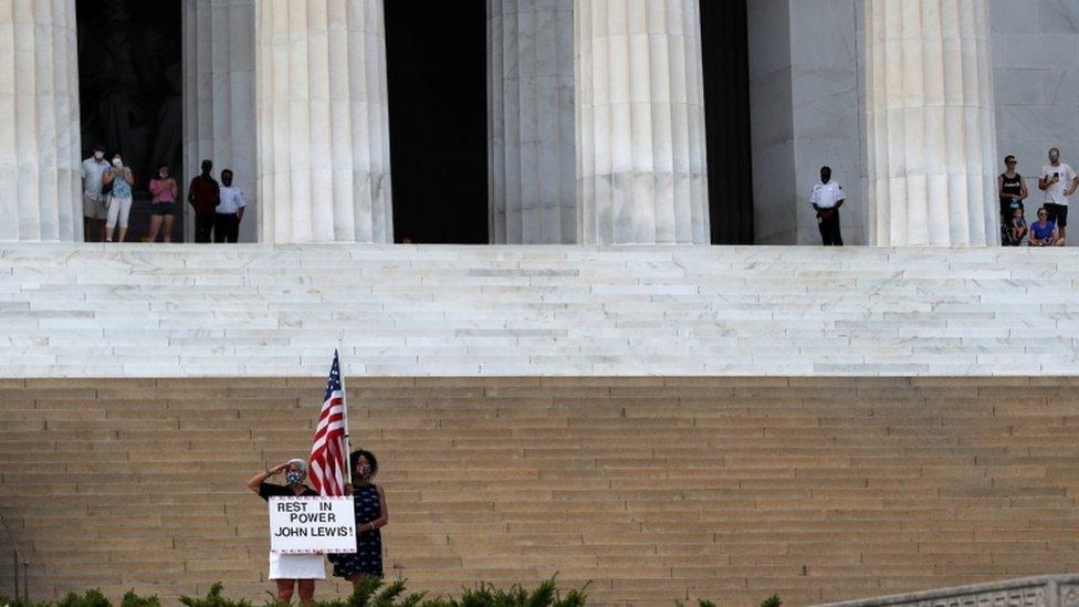 People watch as a hearse with the flag-draped casket of late Rep. John Lewis, (D-GA), drives by the Lincoln Memorial, in Washington, U.S., July 27, 2020