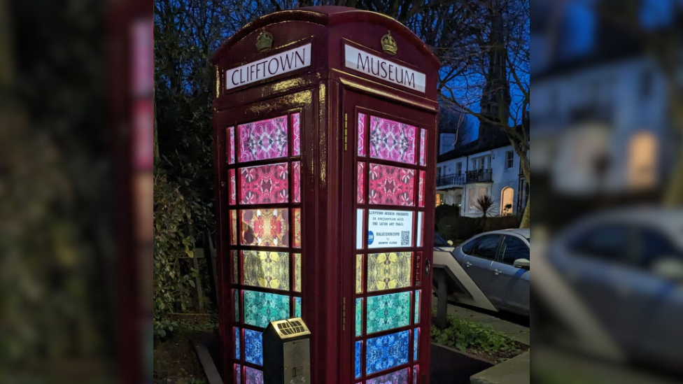 The telephone box lit up at night