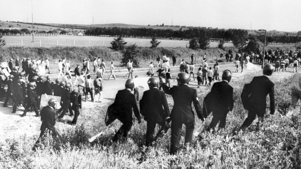 Police with riot gear chase protesters at the Orgreave Coking Plant, at Rotherham. in June 1984