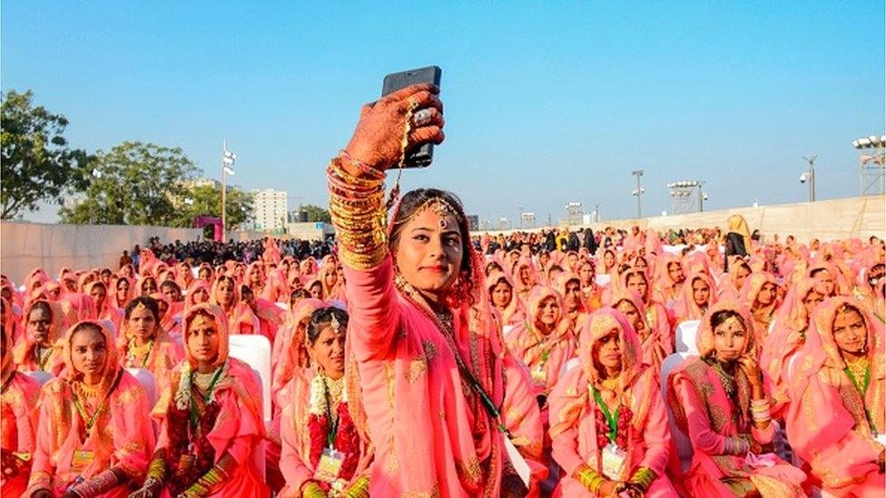 A Muslim bride takes a selfie with her mobile phone as she participates in an 'All Religion Mass Wedding' ceremony at Sabarmati Riverfront in Ahmedabad on February 8, 2020. (P