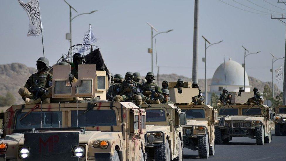 Taliban fighters hold a military parade with equipment captured from the US army in Kandahar.