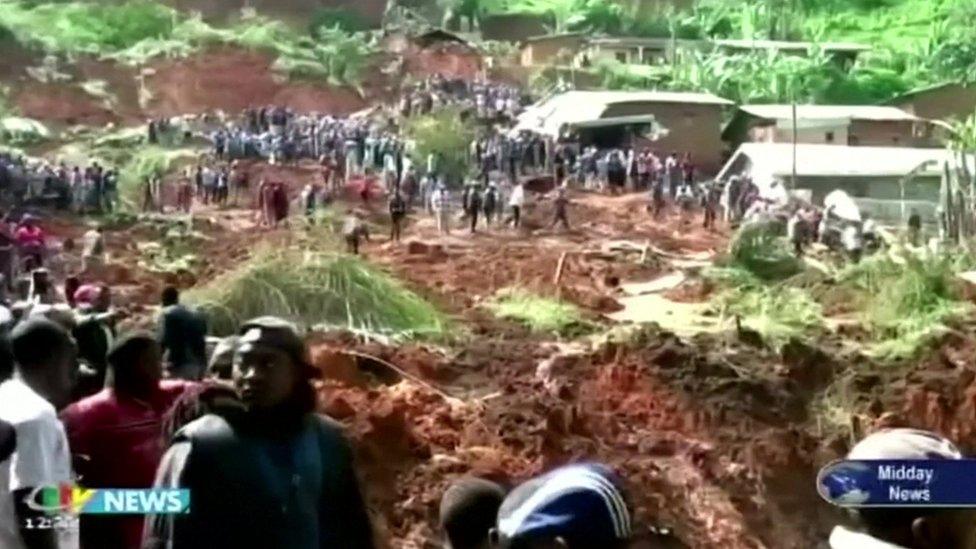 People looking on as the area of the mudslide is searched