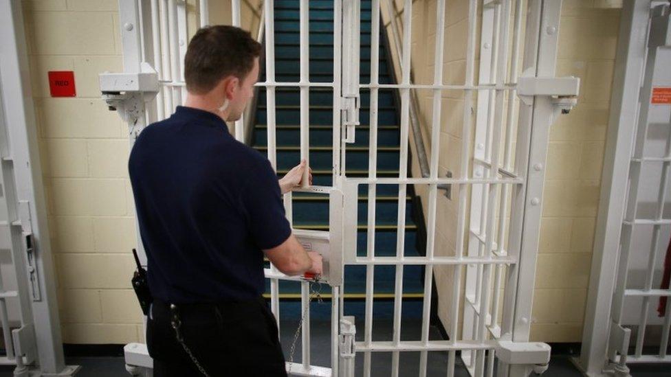 Prison officer locking a door