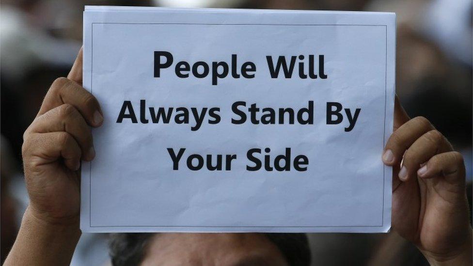 A supporter of Yingluck Shinawatra outside court in Bangkok (1 Aug 2017)