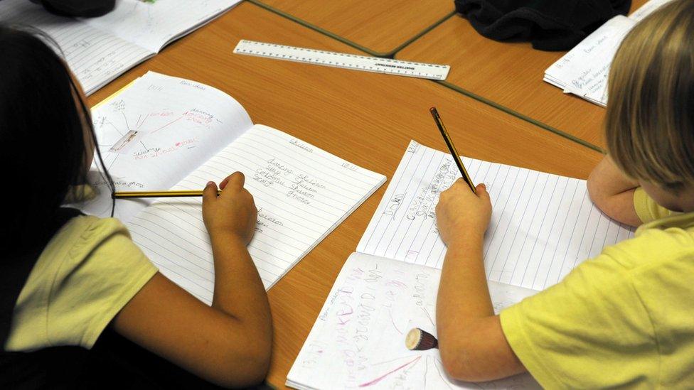 Young girls writing in an exercise book