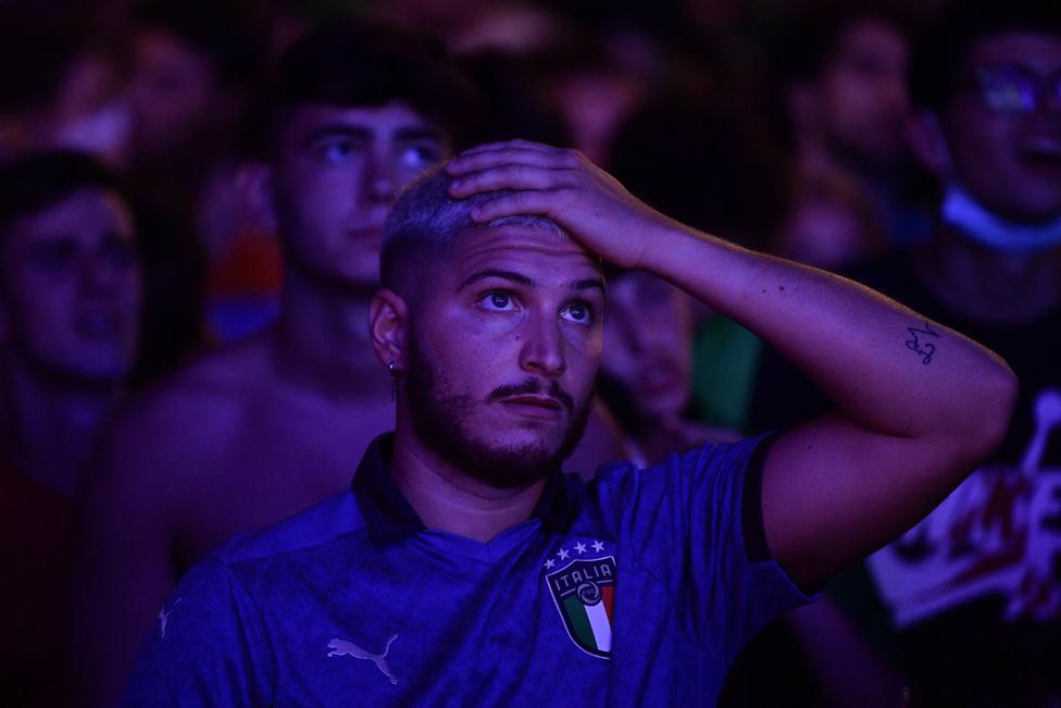 A supporter of the Italian national football team reacts as he watches the UEFA EURO 2020 final football match between England and Italy, at the Piazza del Popolo fanzone, in Rome on July 11, 2021.