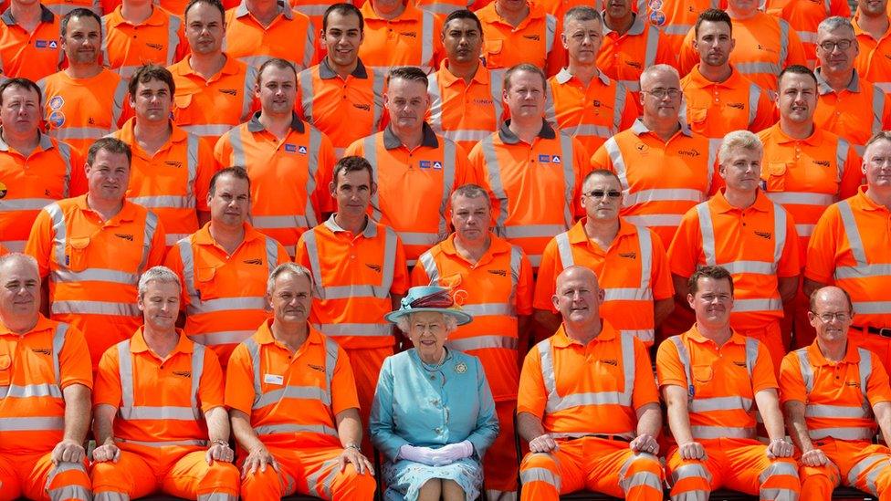 Queen Elizabeth II poses with some of the construction workers as she visits Reading Railway after redevelopement on July 17, 2014 in Reading