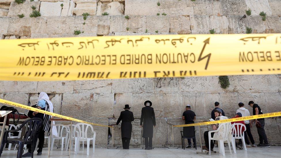 Jews pray in an area restricted to 10 people at the Western Wall in Jerusalem (16 March 2020)