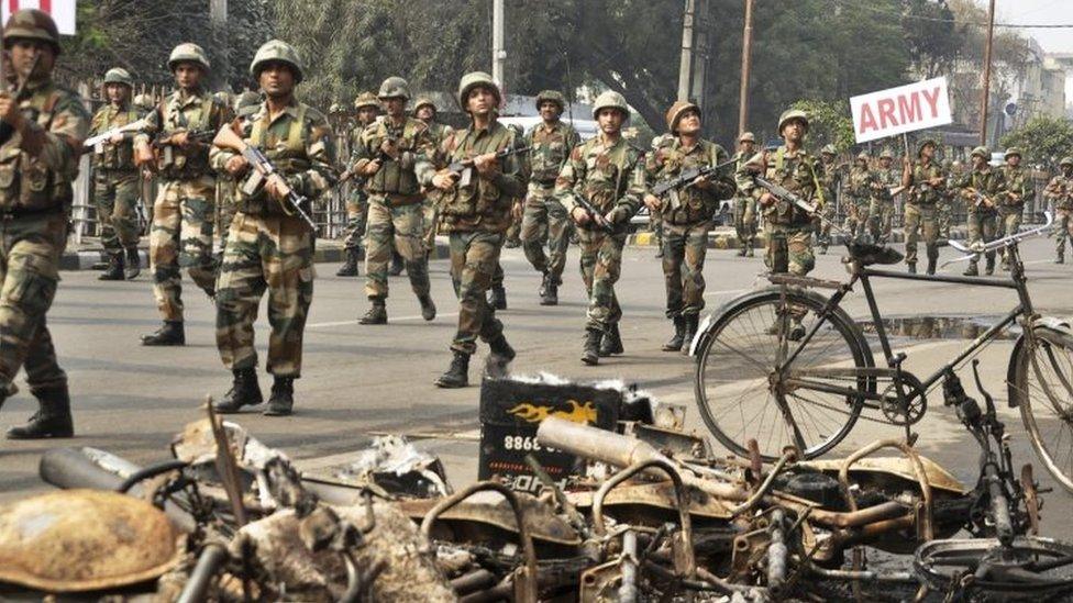 Indian army soldiers conduct a flag march at Rohtak (20 February 2016)