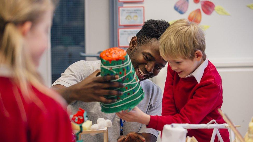 A young primary school pupil enjoys an art class with their teacher