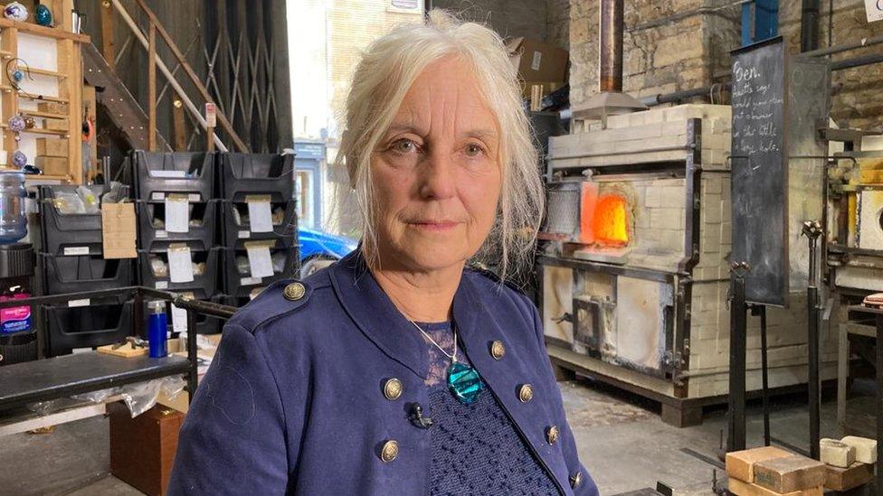 Woman stood in glass-blowing workshop