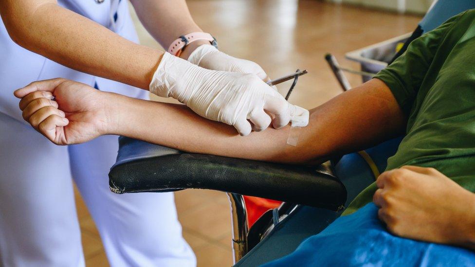 A nurse helps a patient who has given blood