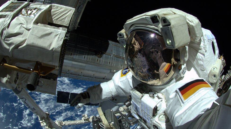 Alexander Gerst taking a selfie in his suit outside the ISS