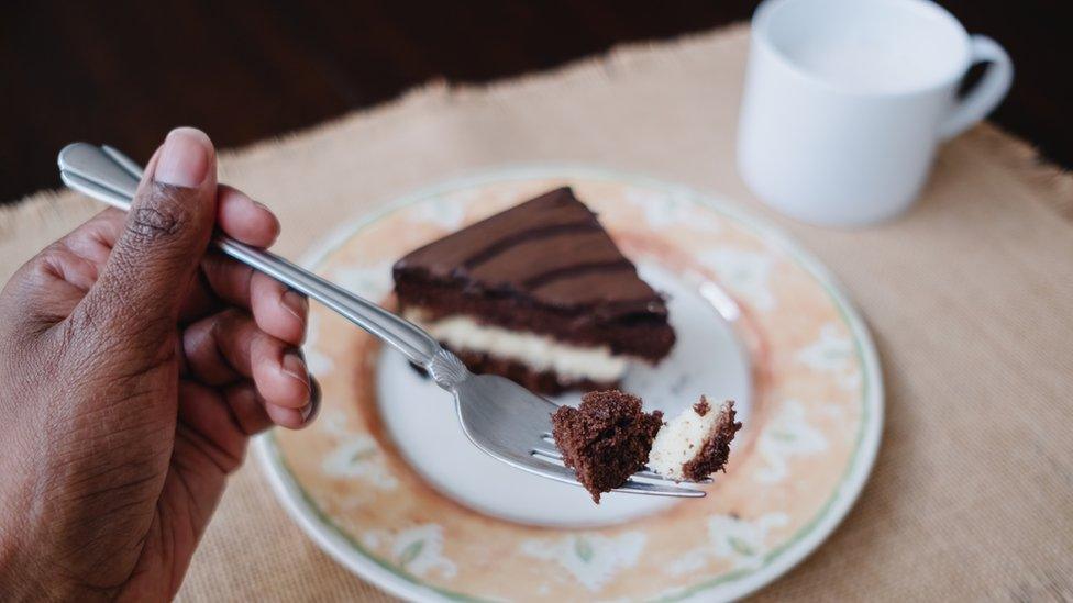 Woman Enjoys Slice of Cake With Cup of Milk