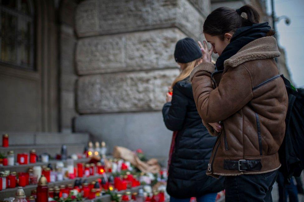 A woman mourns outside the building of Philosophical Faculty of Charles University following a mass shooting earlier this week, on December 23, 2023 in Prague, Czech Republic.