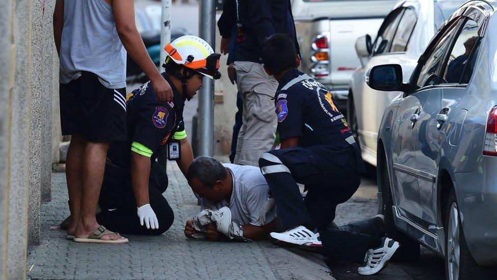 Emergency services personnel attend to a man injured in one of the blasts in Hua Hin, 12 August 2016.