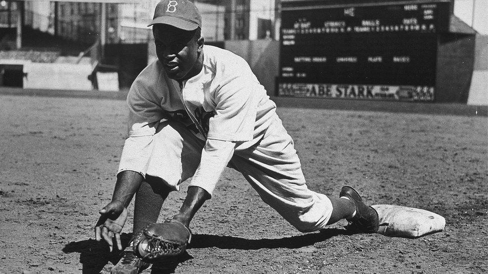 Jackie Robinson grounding a ball in an exhibition game against the New York Yankees in 1950