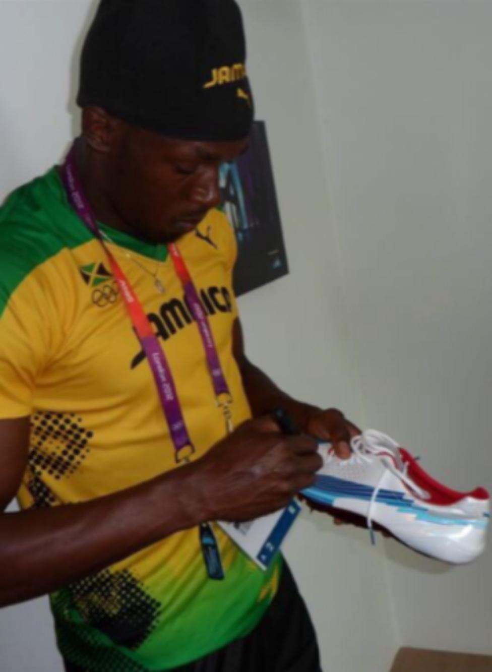 Usain Bolt signing the shoes