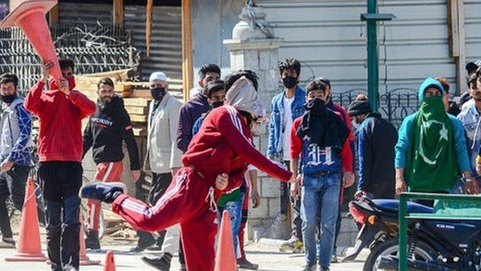 A Kashmiri protester throws a stone at government forces during the demonstration against the revocation of Article 370.