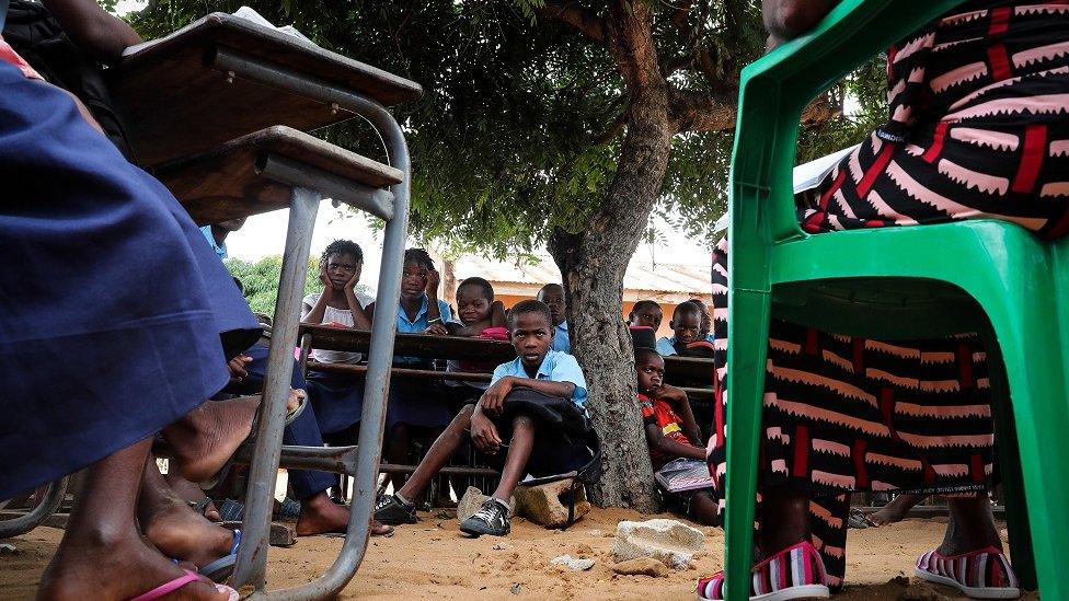 A teacher gives a lesson to the students at the open-air classes at the primary school in the neighborhood of Mahate, in Pemba